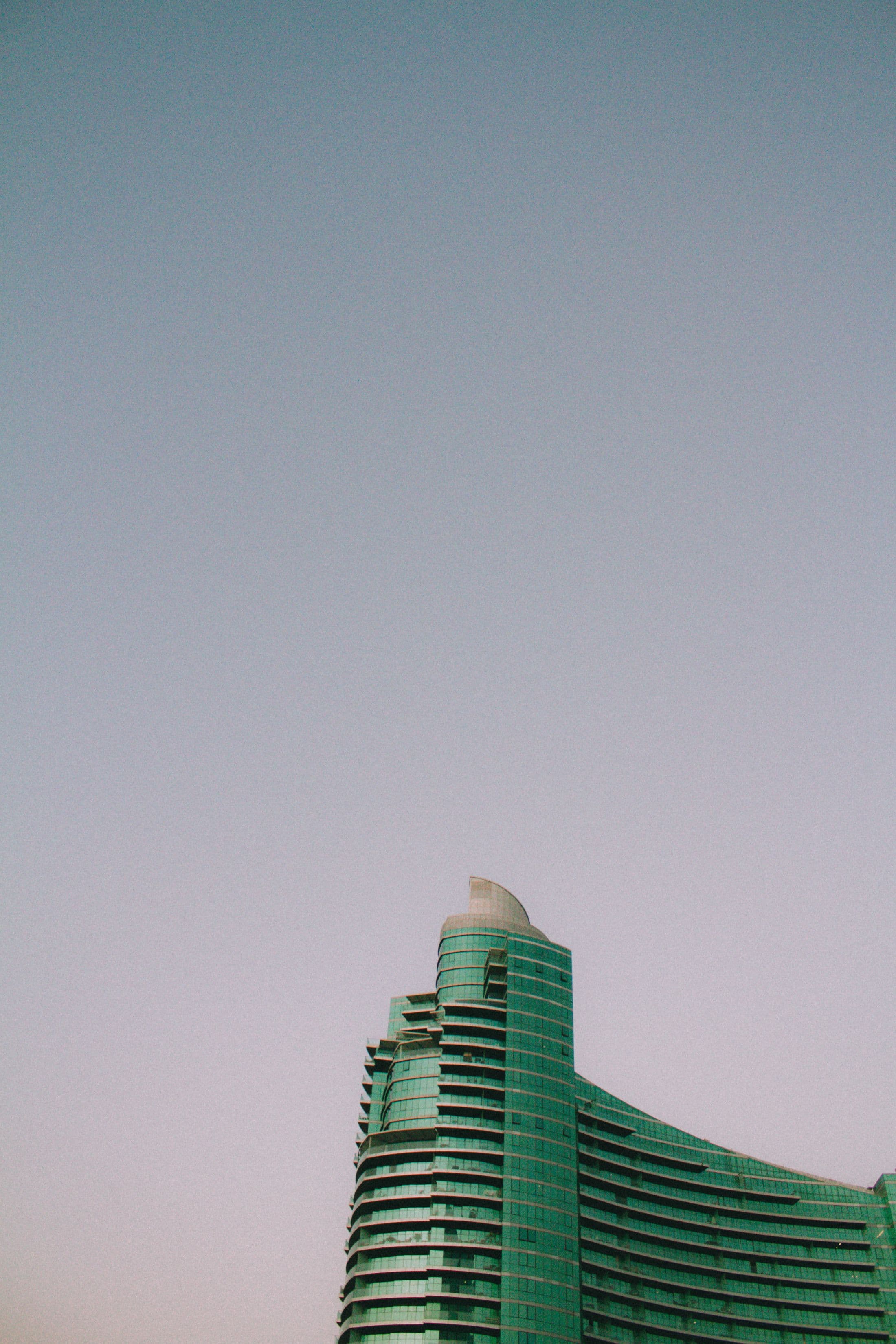 Green glass architecture rising into the Dubai sky
